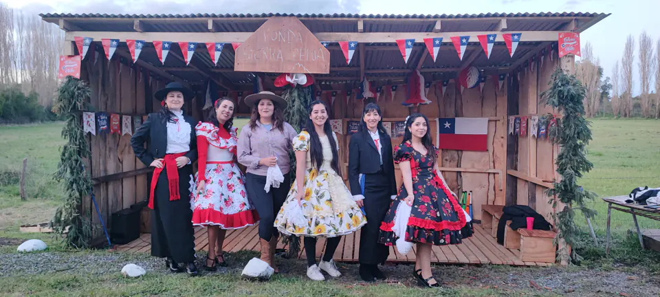 Curso reunido frente a la cabaña de madera